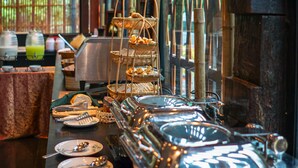 Uma mesa de buffet com diversos alimentos e utensílios de servir.