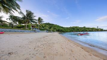 Na praia, espreguiçadeiras, guarda-sóis, toalhas de praia