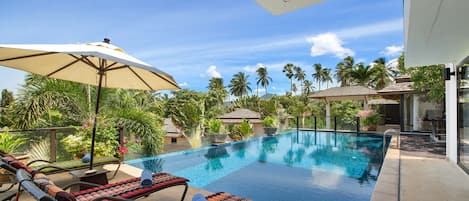 Outdoor pool, an infinity pool, pool umbrellas, pool loungers