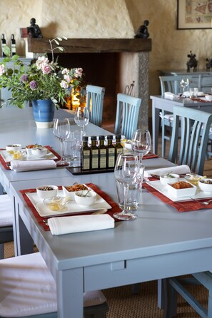 A dining table set with plates, bowls, glasses, and bottles, surrounded by chairs. - Azienda Agricola Chiarentana (Chianciano Terme)