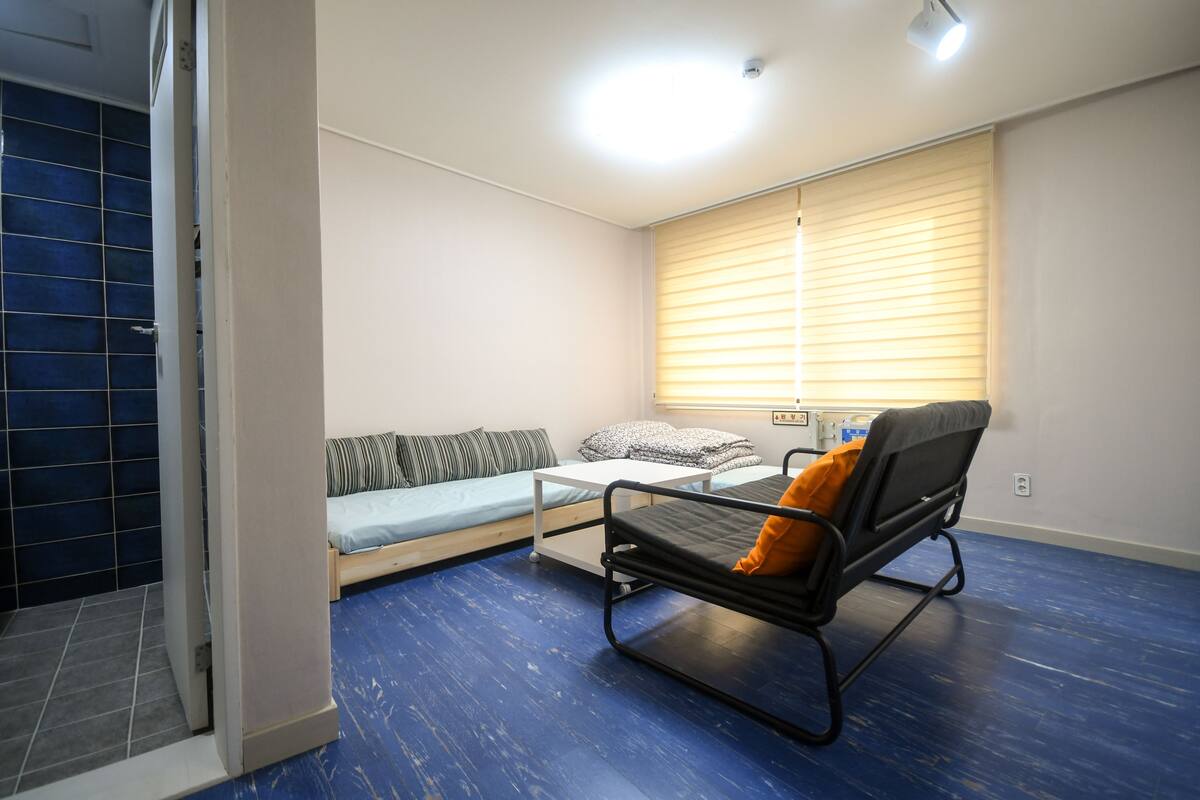A compact room with a bed, a sofa, and a small table.