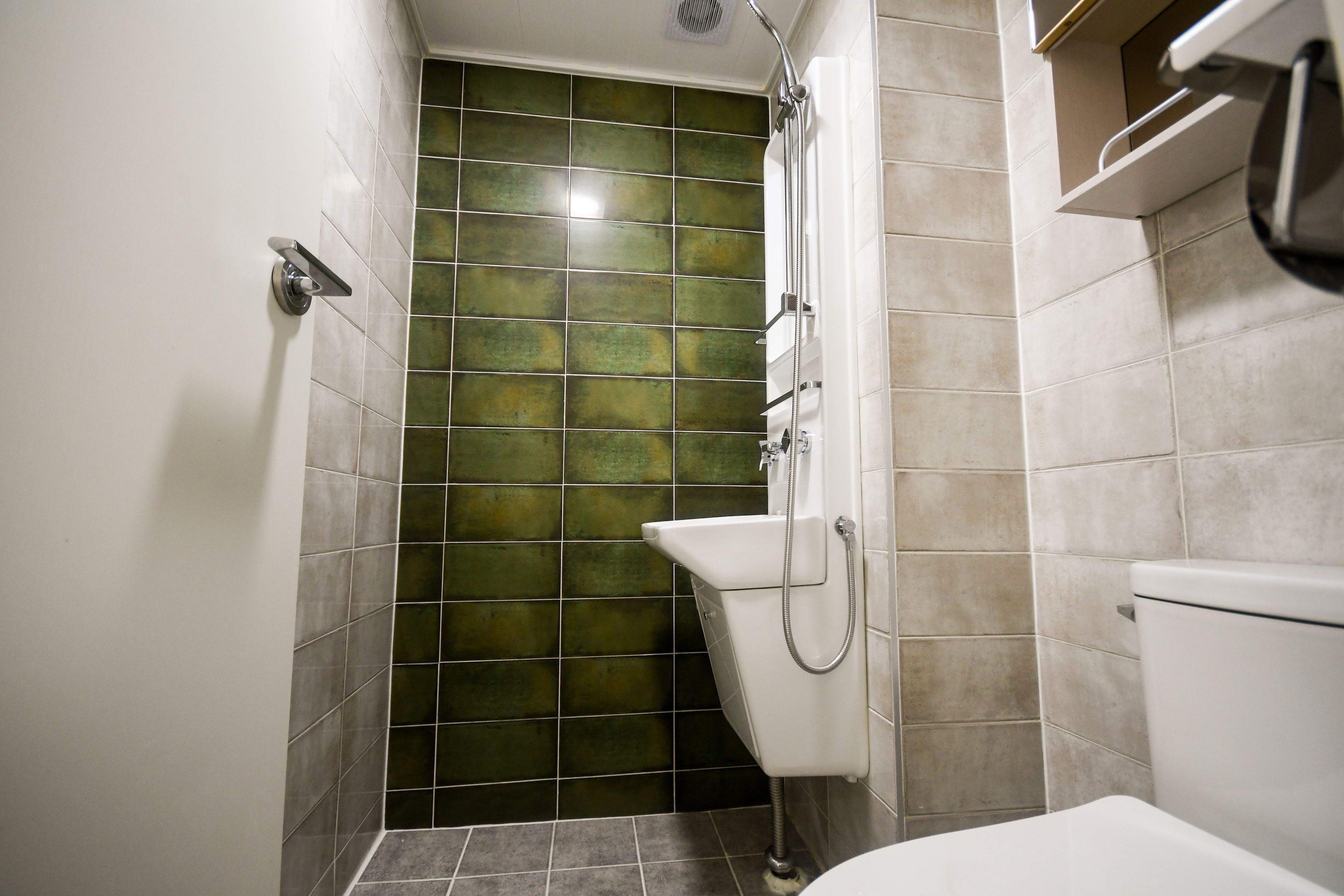 A bathroom with a shower, a toilet, and a sink.