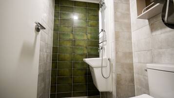 A bathroom with a shower, a toilet, and a sink.