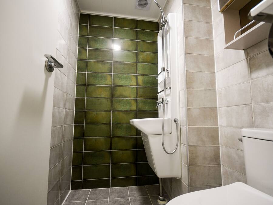 A bathroom with a shower, a toilet, and a sink.