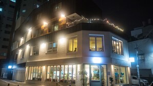 A two-story building with a ground-floor restaurant and upper-floor residential units. - BLUEHUM Guesthouse - Hostel (Incheon)