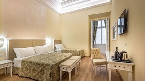 A hotel room with a large bed, a desk with a kettle, and a chair. - Residenza Alessandra (Florence)