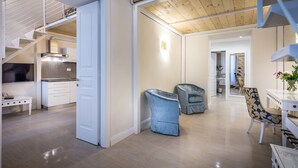 A spacious living area with a wooden staircase, a dining table with chairs, and a kitchen in the background. - Residenza Alessandra (Florence)