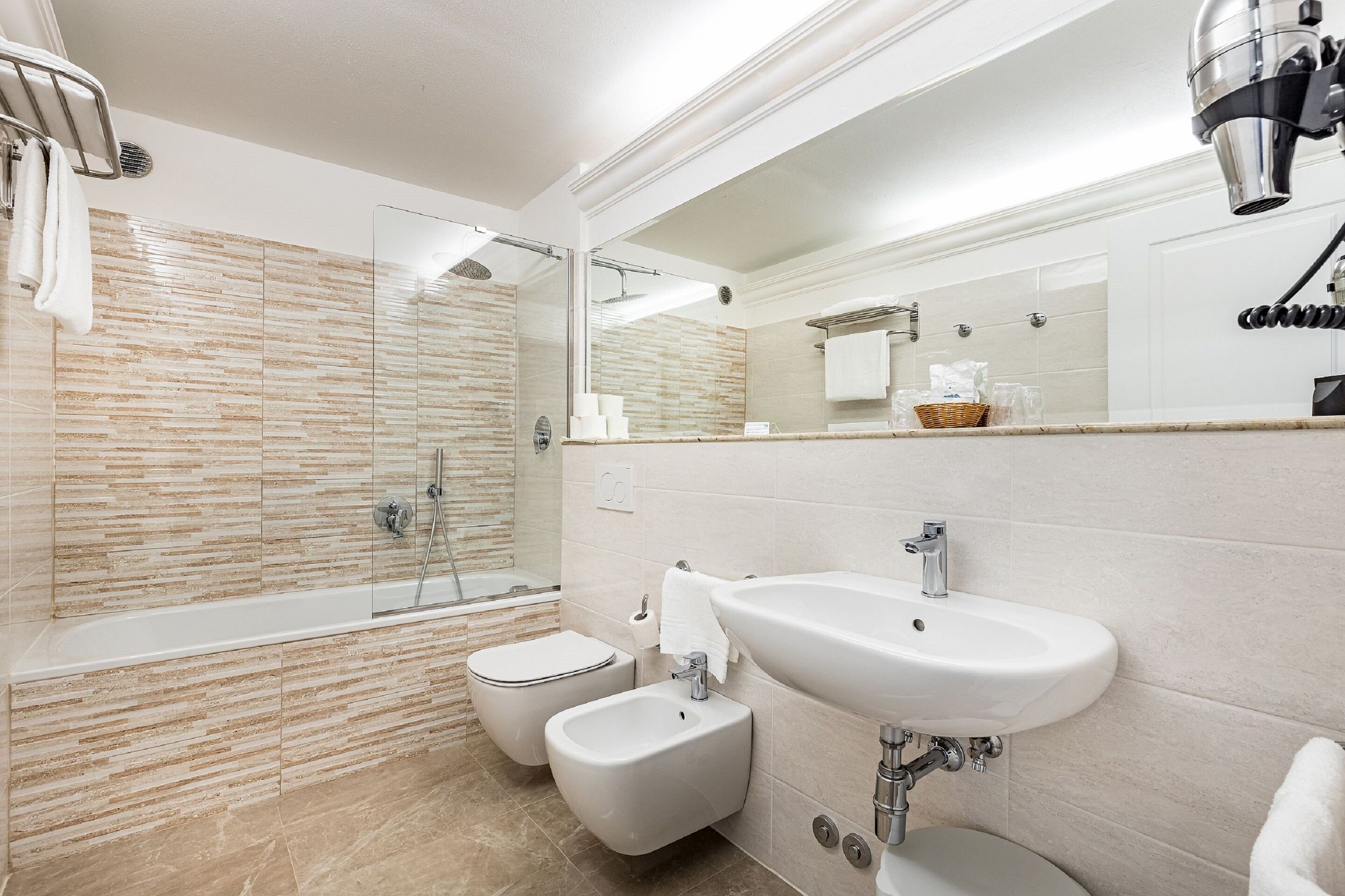 A modern bathroom with a bathtub, bidet, and sink.