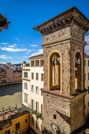 A historic stone tower with a clock, arched windows, and a bell. - Residenza Alessandra (Florence)