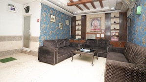 A living room with patterned sofas, a coffee table, and a television.