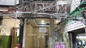 A hotel entrance with a sign reading "SAIDHAM" and a sign for "SAI DHAM INTERNATIONAL".