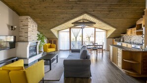 Une cuisine moderne avec des meubles en bois, un four encastré et un coin repas comprenant une table et des chaises.