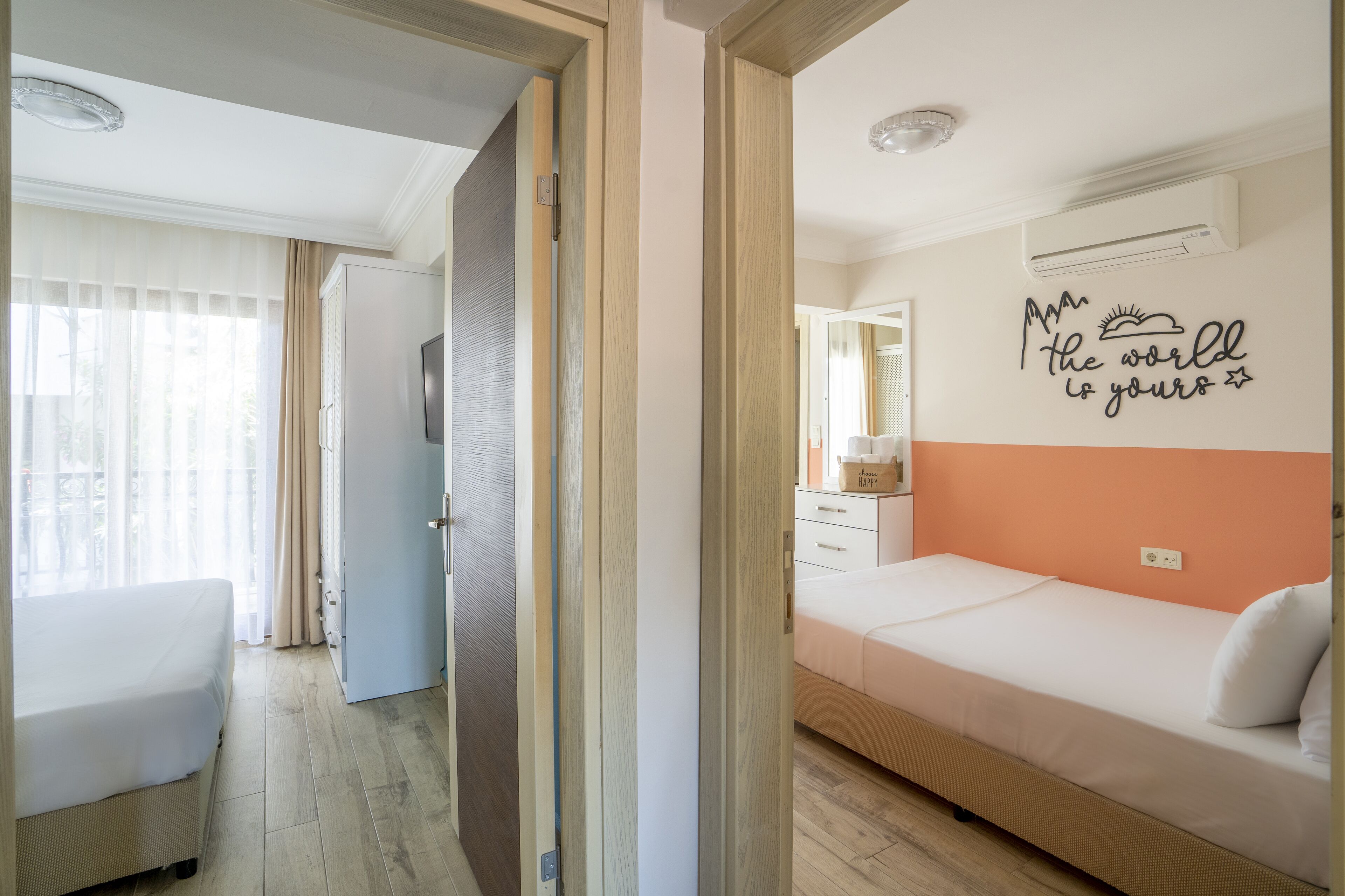 A hotel room with a bed, a desk, a chair, and a wardrobe.