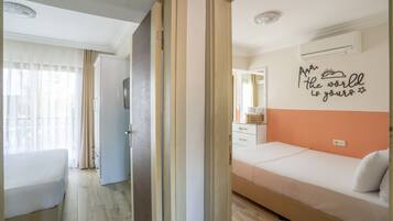 A hotel room with a bed, a desk, a chair, and a wardrobe.