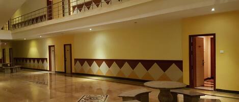 A spacious lobby with a high ceiling, a mezzanine level, and a polished floor.