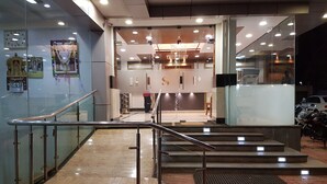 A modern interior with a staircase leading to a reception area. - Hotel Subhalakshmi Palace (Karaikudi)