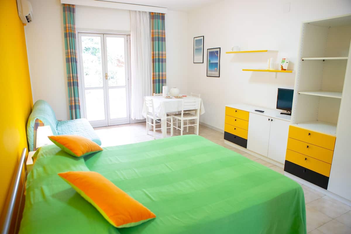 Ein Zimmer mit einem Bett, einem Schreibtisch und einem Fernseher.