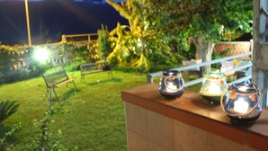 Un jardín con un banco y una barandilla.