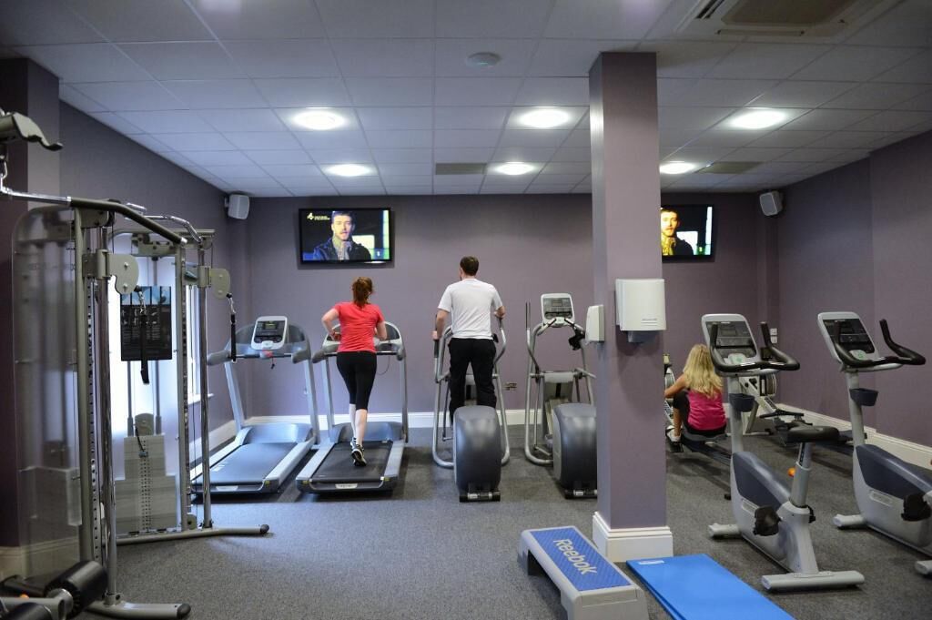 A gym with treadmills, elliptical machines, and weightlifting equipment.