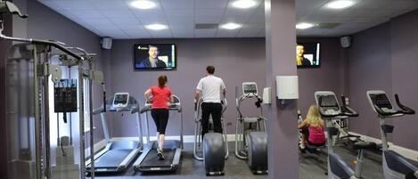 A gym with treadmills, elliptical machines, and weightlifting equipment.