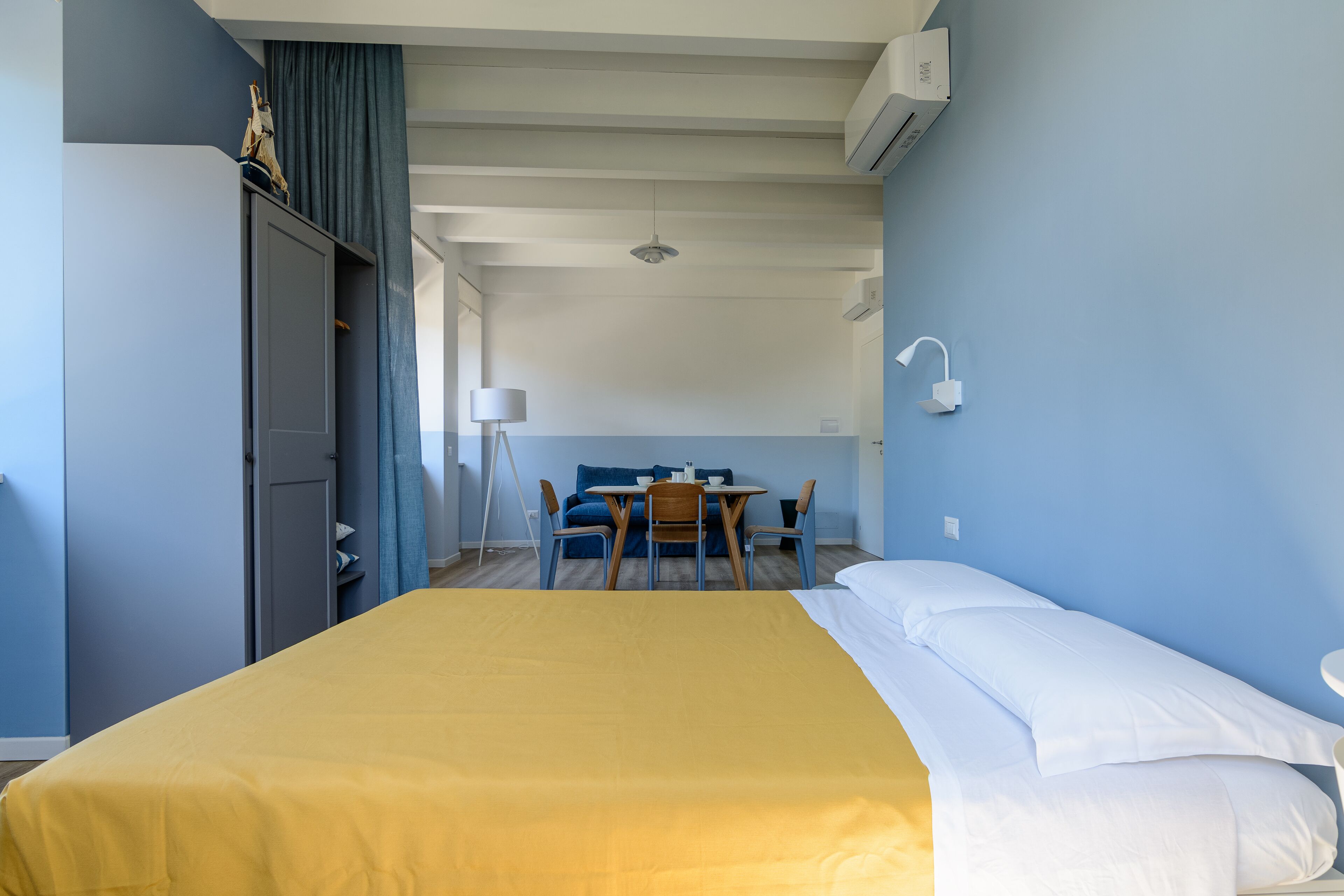 Et hotelværelse med en seng, et skrivebord og en stol.