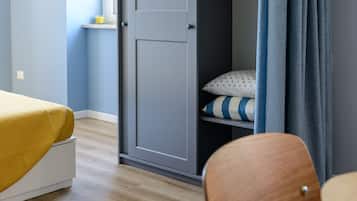Un dormitorio con cama, armario y una silla.