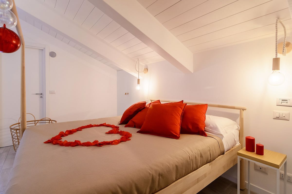 A bedroom with a bed, a bedside table, and a nightstand.