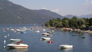 Un lago con numerosos barcos y una orilla concurrida.