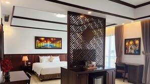 Een hotelkamer met een bed, een bureau, een minibar en kunst aan de muur.