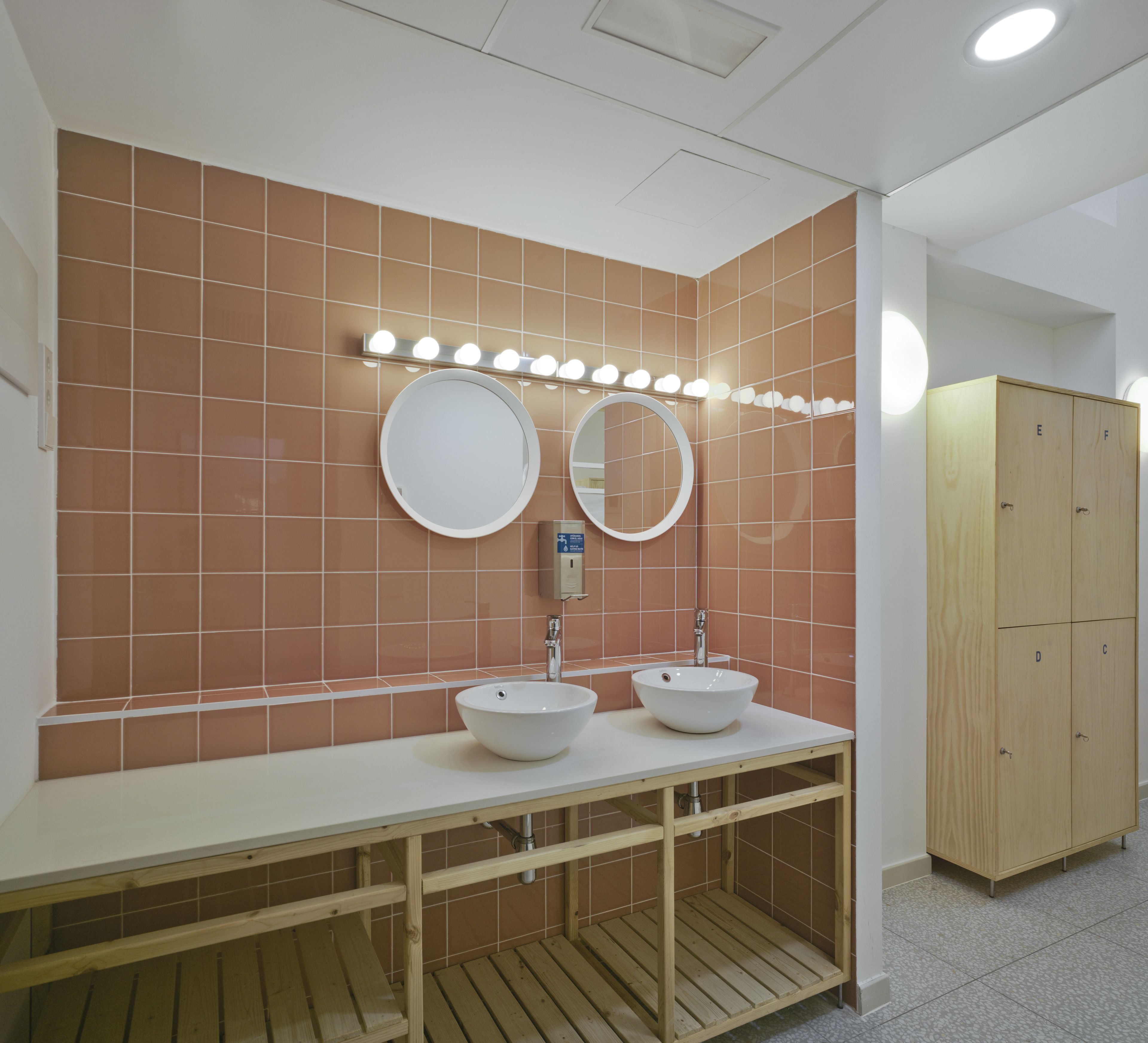 Un baño con dos lavamanos, un espejo y un mueble de madera.