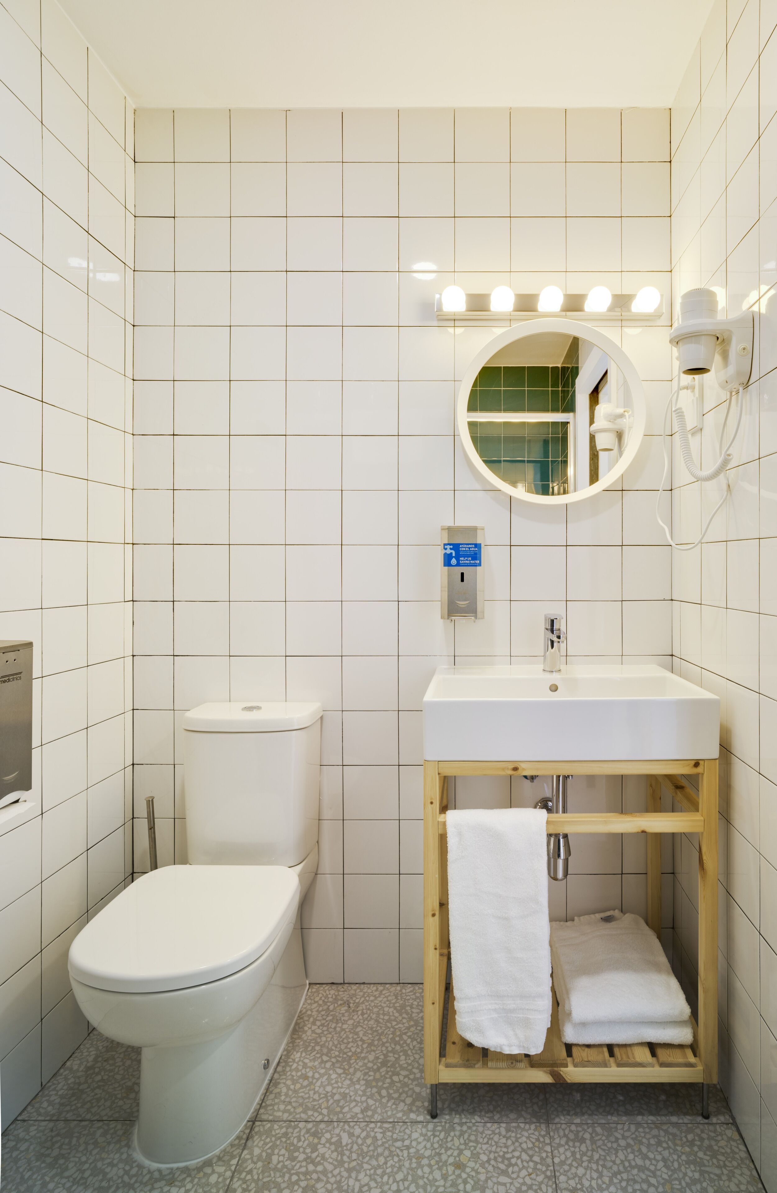 Ein Badezimmer mit Toilette, Waschbecken, Spiegel und Handtuchhalter.