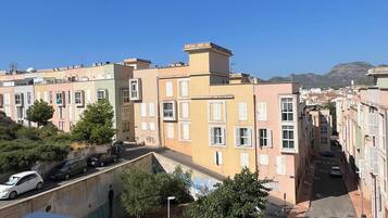 Zona residencial con edificios de varios pisos, calles estrechas y cielo azul despejado.