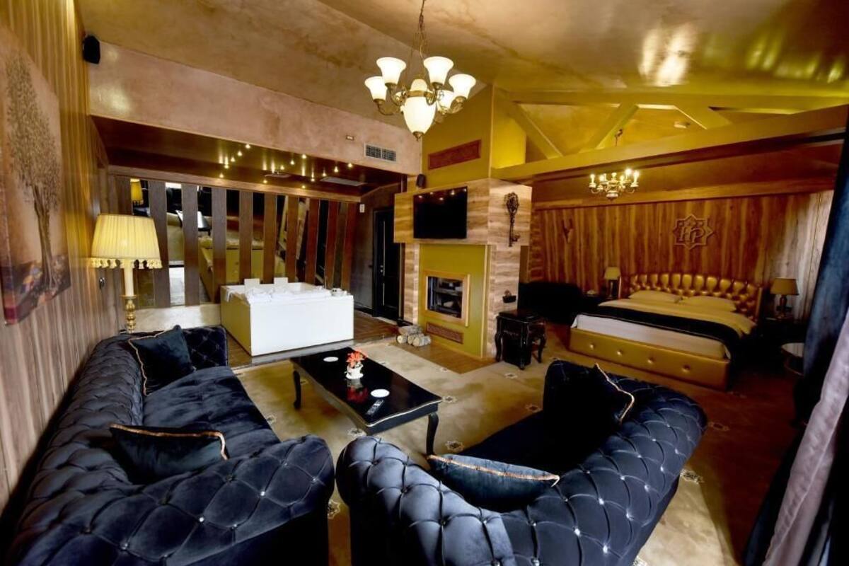 A spacious living room with a sofa set, a coffee table, and a fireplace.