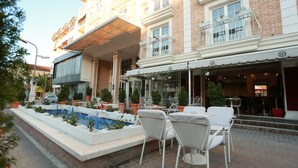 Un hotel con terraza al aire libre, piscina y zona de patio cubierta.