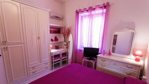 A bedroom with a bed, a desk, a chair, a dresser, a mirror, and a window with curtains. -  L'Aurora Viola (Carbonia)
