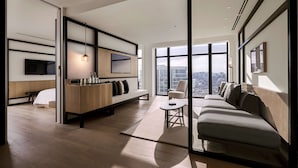 A modern living room with a sofa, a bench, a coffee table, and a TV mounted on the wall. - Alila Bangsar, Kuala Lumpur (Kuala Lumpur)