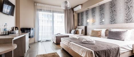 A modern hotel room with a large bed, a desk, and a view of the city.