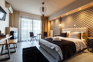 Una habitación de hotel moderna con una cama grande, un escritorio con silla, un televisor y un papel tapiz estampado.