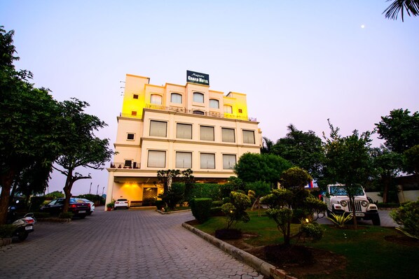 A multi-story hotel with a prominent sign, a paved driveway, and well-maintained landscaping. - Hotel Majestic Grand (Jalandhar)