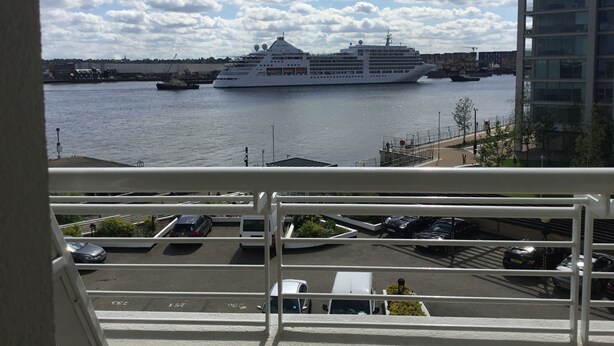 A view of a cruise ship docked at a port with a clear sky and clouds. - Nice and private rooms (London)