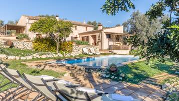 Una piscina al aire libre, sillones reclinables de piscina