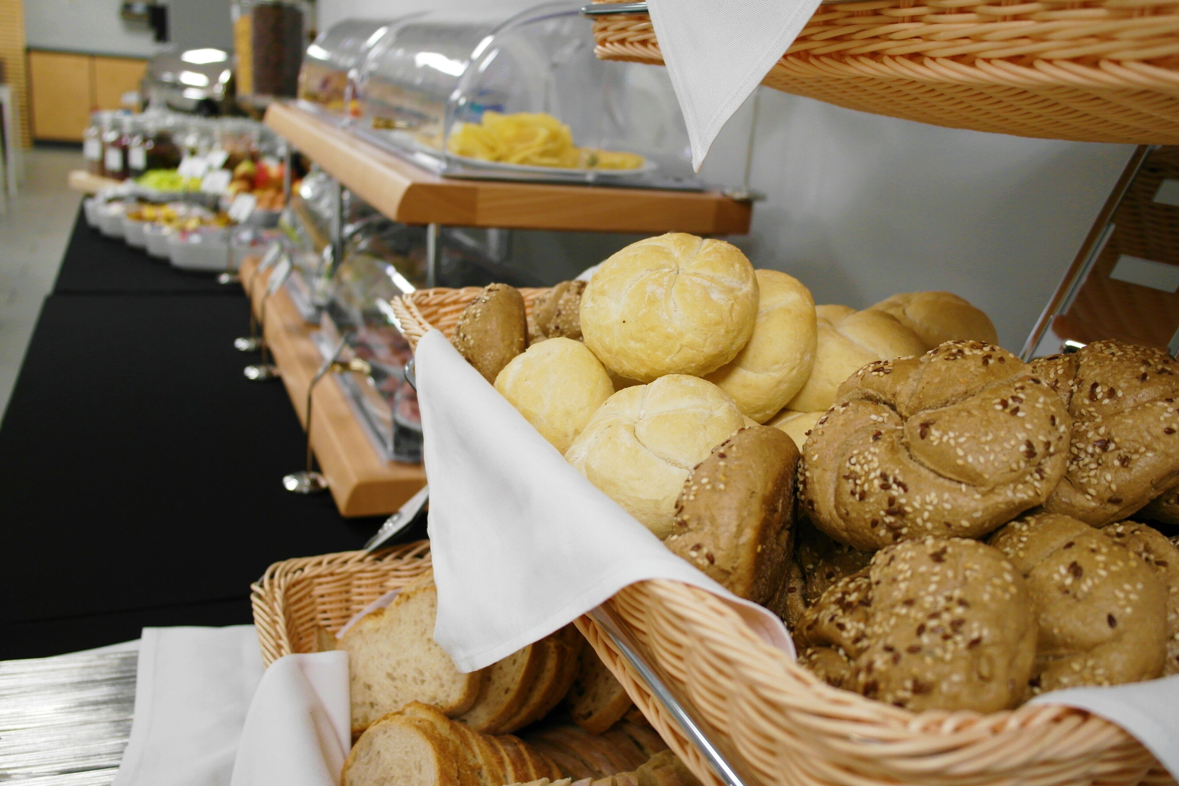 A buffet with various breads and pastries.