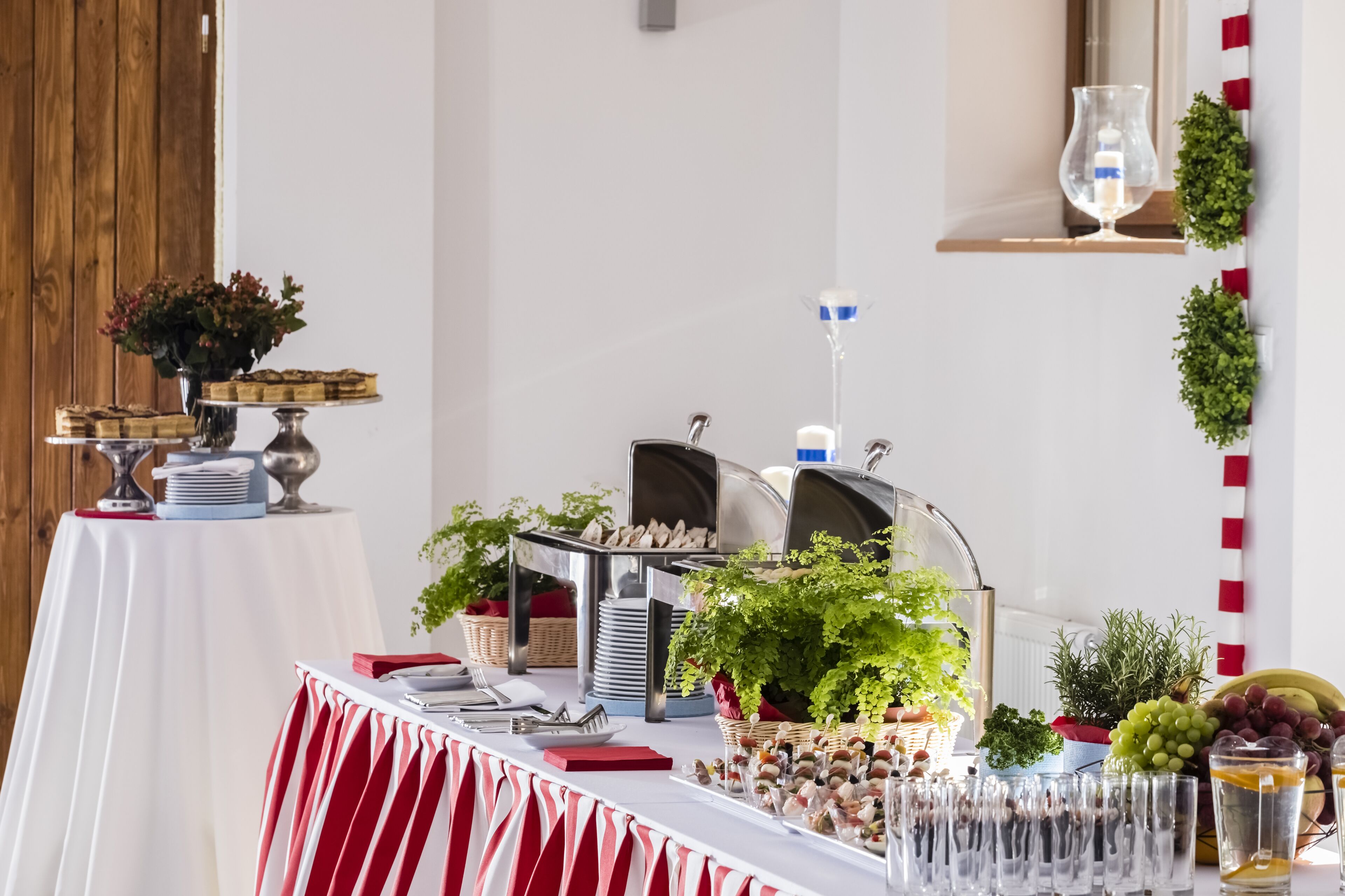 Un buffet proposant une variété de plats, d’ustensiles et de plantes décoratives.