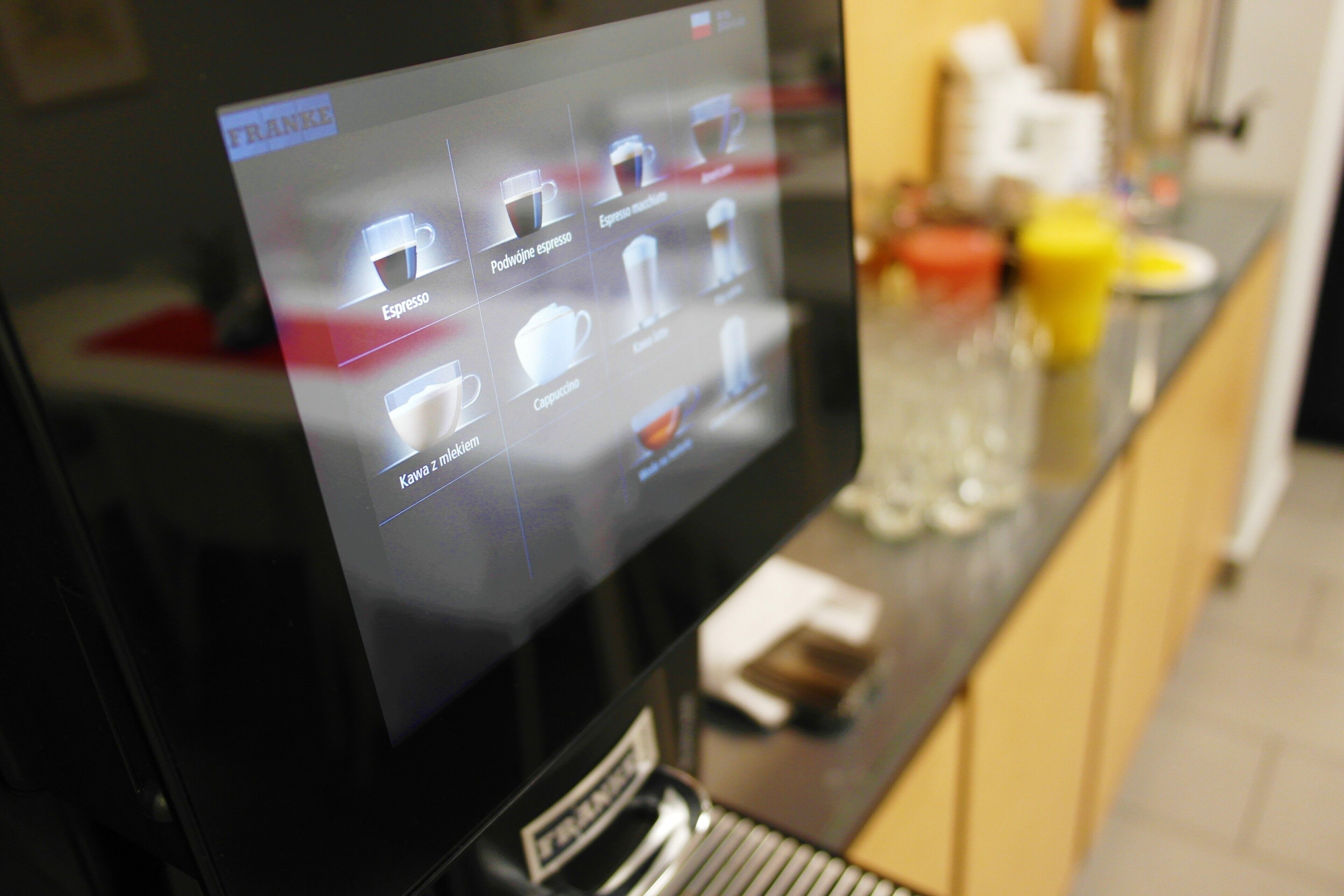 En digital menu på en skærm, der viser forskellige kaffetyper.