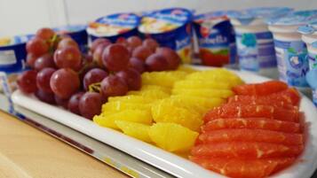 Ein Teller mit Obst und Joghurtbechern.