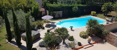 Een buitenzwembad, parasols bij het zwembad en ligstoelen