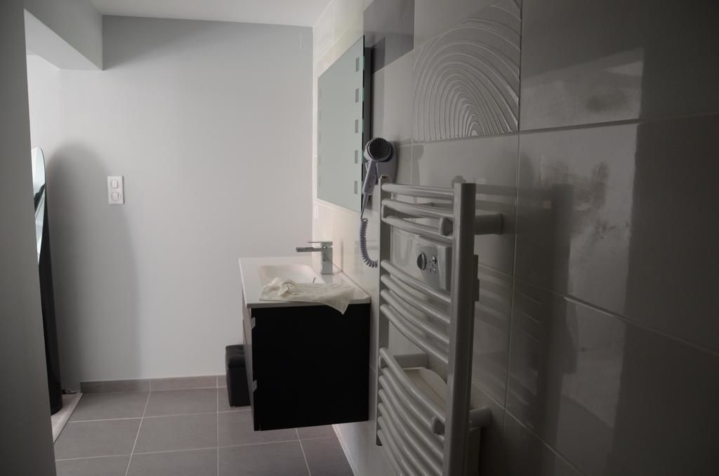 Une salle de bain moderne dotée d’un lavabo intégré, d’un porte-serviettes et d’un radiateur fixé au mur.