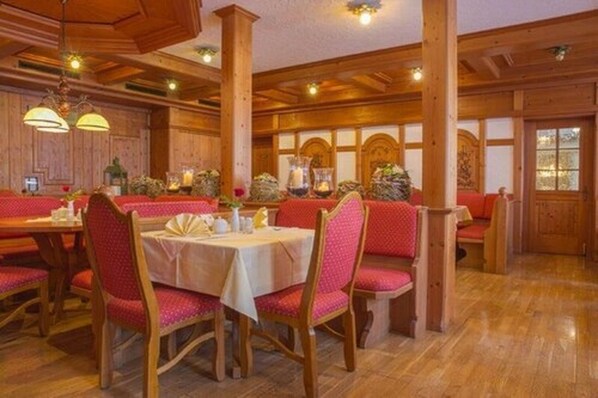 A traditional inn with wooden interiors, red upholstered seating, and a warm ambiance. - Hotel Stolberger Hof (Südharz)
