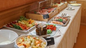 A buffet with various food items including fruits, salads, and meats. - Hotel Stolberger Hof (Südharz)