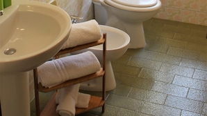 A bathroom with a toilet, sink, and shower area. - Lucy Apartment (Ragusa)